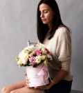 Flowers in a hatbox with roses and lisianthus in addition to peony varieties of roses